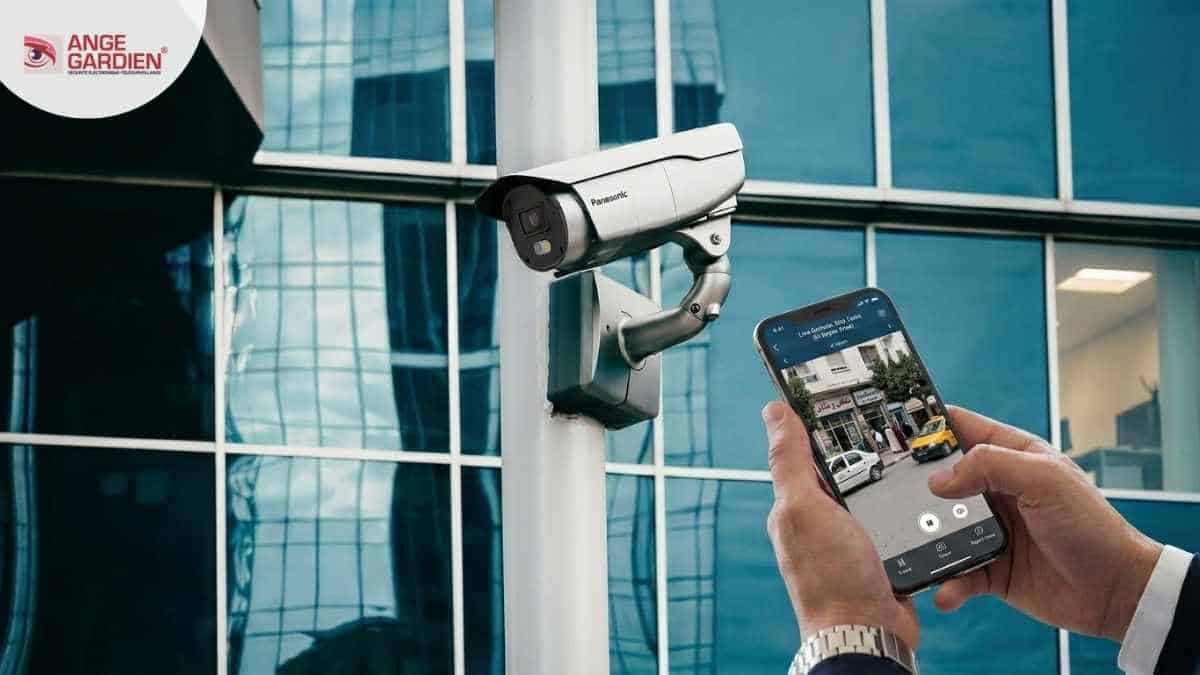 Caméra de surveillance Panasonic avec supervision en direct sur smartphone devant un bâtiment moderne en Tunisie